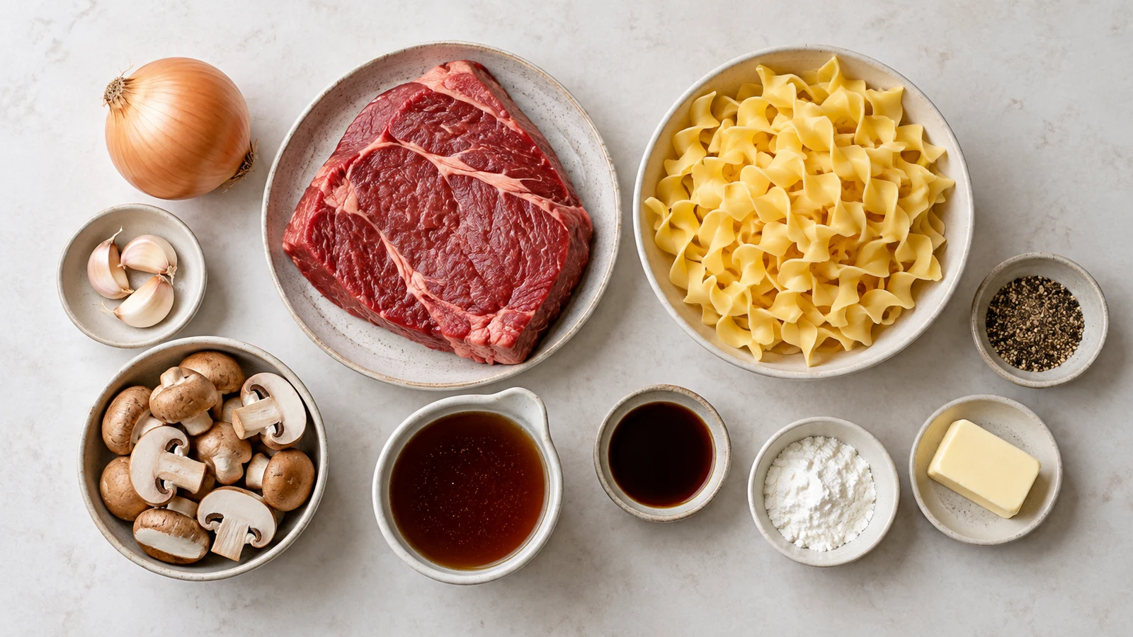 Beef tips and noodles recipe: ingredients for beef tips and noodles arranged in a bright, organized flat lay.